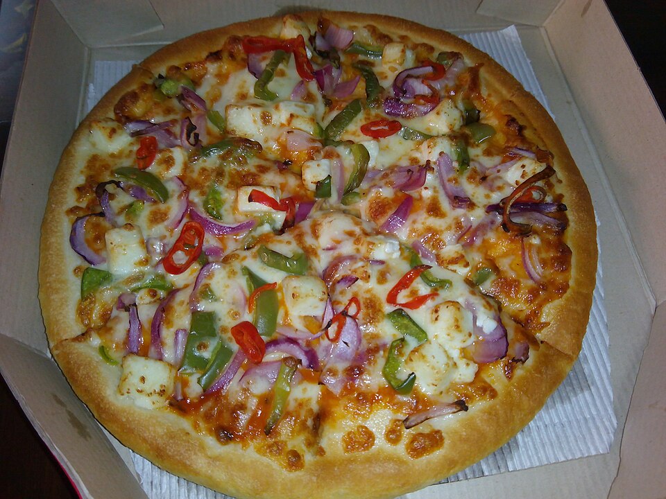 Paneer pizza with red onion and peppers